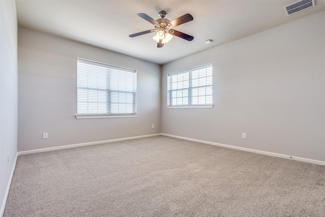 unfurnished room with carpet floors, baseboards, and visible vents