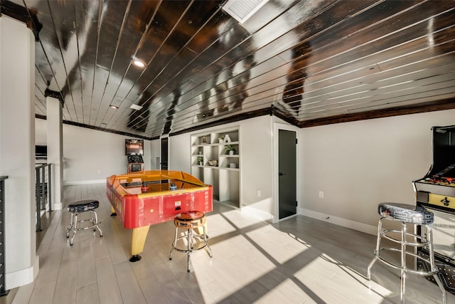 recreation room featuring built in features, ornamental molding, wooden ceiling, and light hardwood / wood-style flooring