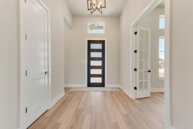 foyer with light hardwood / wood-style flooring and a notable chandelier