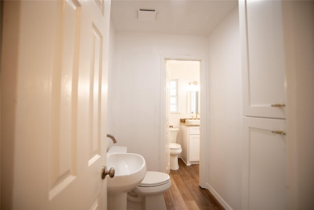 bathroom featuring sink, hardwood / wood-style floors, and toilet