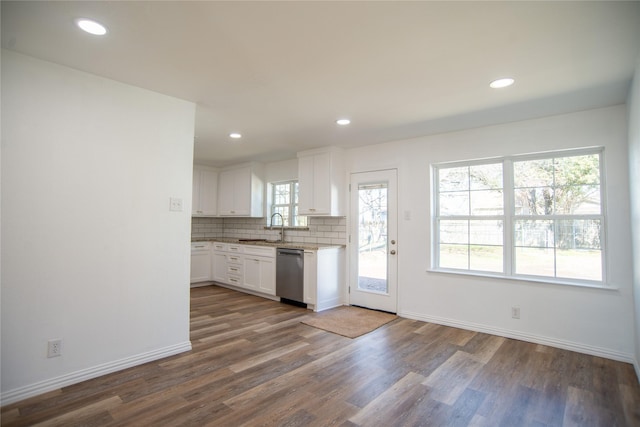 kitchen with white cabinetry, sink, backsplash, stainless steel dishwasher, and dark wood-type flooring