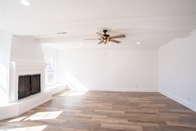 unfurnished living room with ceiling fan, beam ceiling, and hardwood / wood-style floors