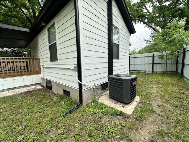 view of side of property with central AC and a yard