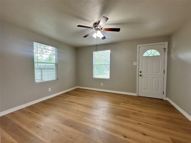 foyer entrance with ceiling fan and light hardwood / wood-style floors