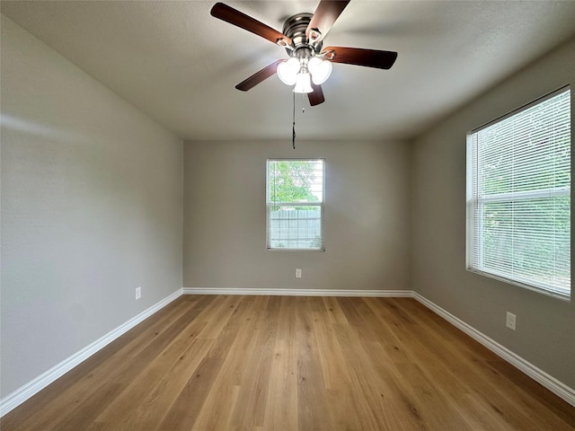 empty room with ceiling fan and light hardwood / wood-style floors