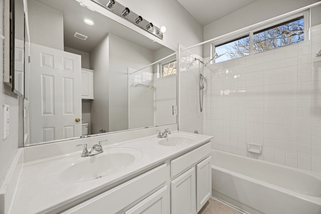 full bathroom with vanity, tiled shower / bath, tile patterned floors, and toilet