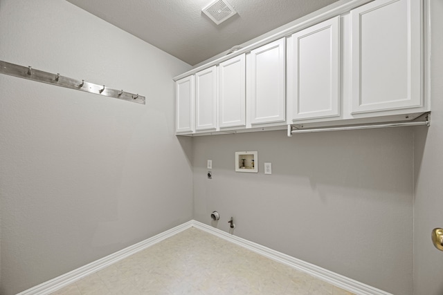 laundry room featuring gas dryer hookup, cabinets, hookup for an electric dryer, and hookup for a washing machine