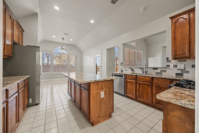 kitchen featuring lofted ceiling, stainless steel appliances, a center island, and sink