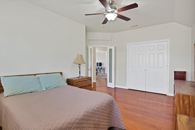 bedroom featuring vaulted ceiling, dark hardwood / wood-style floors, ceiling fan, and a closet