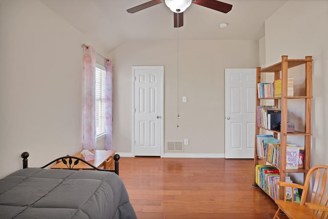 bedroom with ceiling fan, lofted ceiling, and wood-type flooring