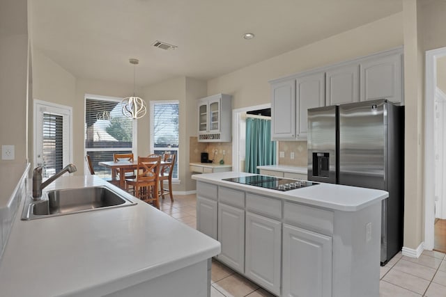 kitchen with a kitchen island, sink, white cabinets, stainless steel refrigerator with ice dispenser, and black electric cooktop