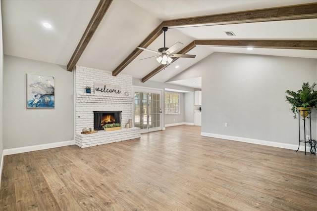 unfurnished living room with lofted ceiling with beams, ceiling fan, hardwood / wood-style floors, and a fireplace