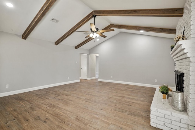 unfurnished living room featuring high vaulted ceiling, a brick fireplace, hardwood / wood-style flooring, ceiling fan, and beam ceiling