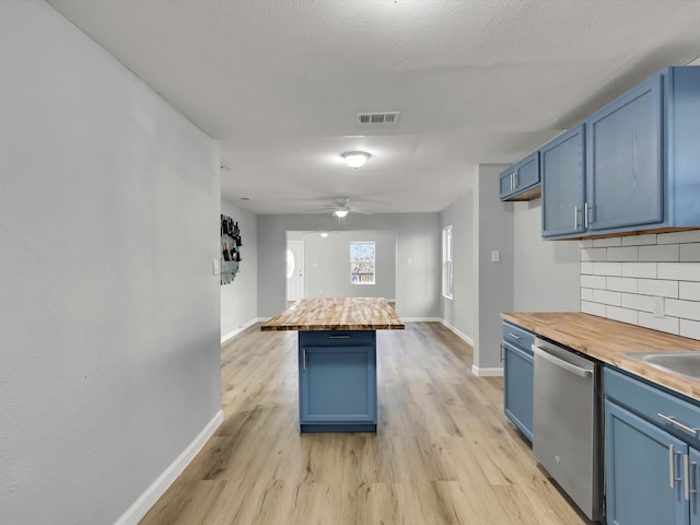 kitchen featuring blue cabinetry, stainless steel dishwasher, backsplash, and wood counters