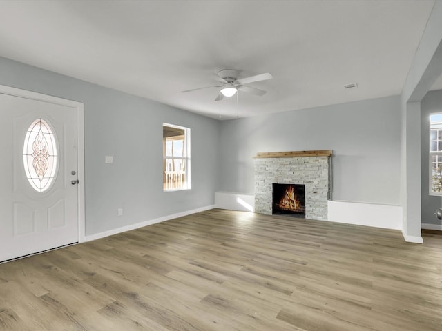 unfurnished living room featuring ceiling fan, a fireplace, and light hardwood / wood-style floors