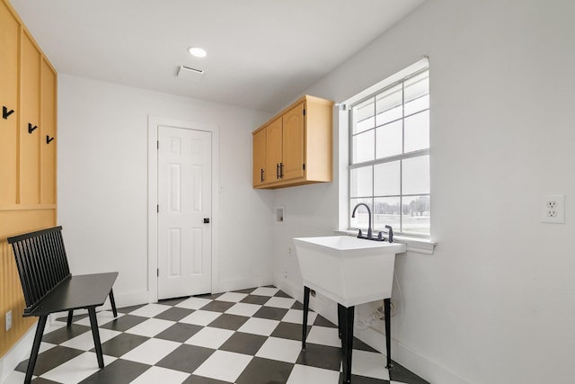 clothes washing area with baseboards, cabinet space, dark floors, and washer hookup