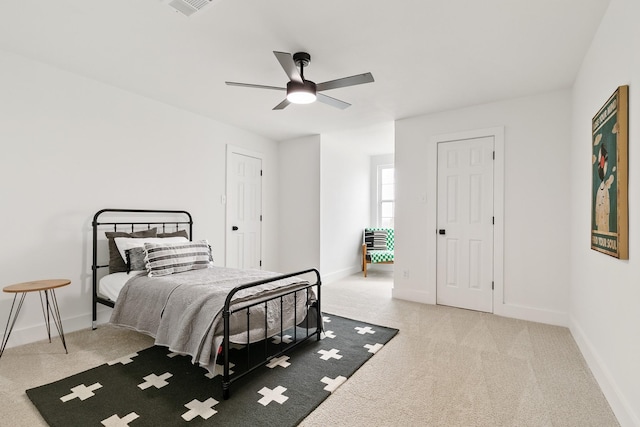 bedroom featuring baseboards, visible vents, light colored carpet, and ceiling fan