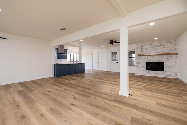 unfurnished living room with a fireplace, recessed lighting, visible vents, light wood-style flooring, and ceiling fan