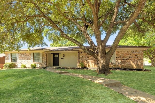 ranch-style home featuring brick siding and a front yard