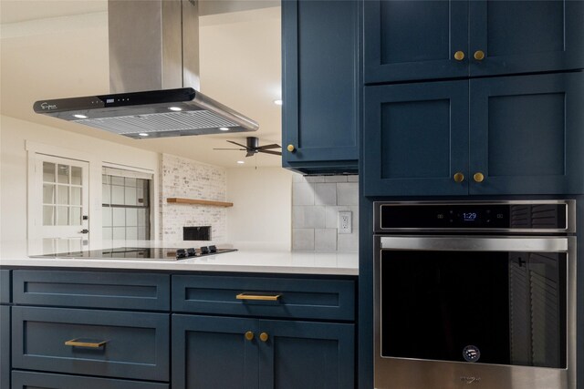 kitchen with black electric cooktop, island exhaust hood, blue cabinets, and stainless steel oven