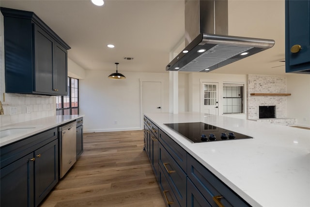 kitchen with stainless steel dishwasher, hardwood / wood-style flooring, island exhaust hood, black electric stovetop, and a fireplace