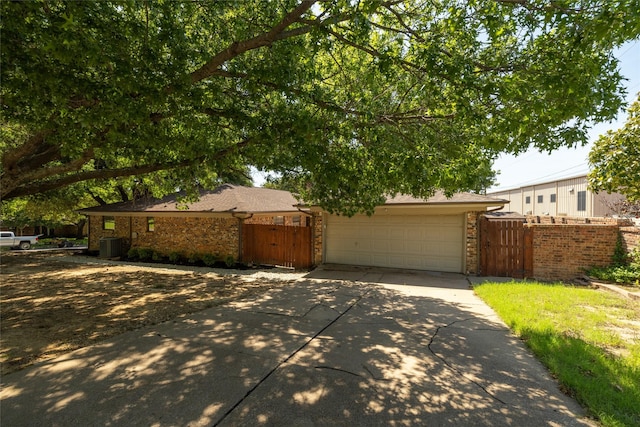 single story home with central AC, brick siding, fence, driveway, and a gate