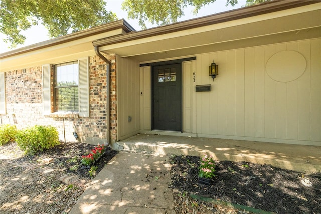 entrance to property featuring brick siding