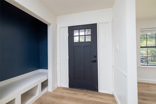 foyer entrance with light wood finished floors and wainscoting