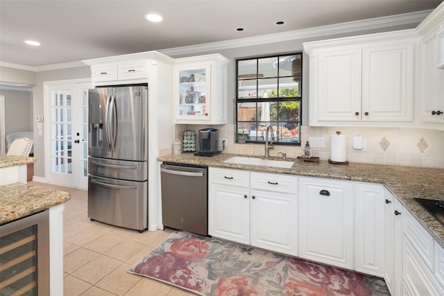 kitchen with sink, appliances with stainless steel finishes, beverage cooler, white cabinets, and dark stone counters