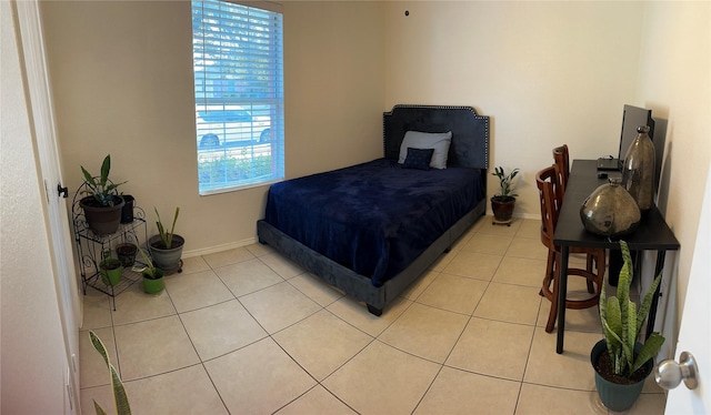 bedroom with light tile patterned floors and baseboards