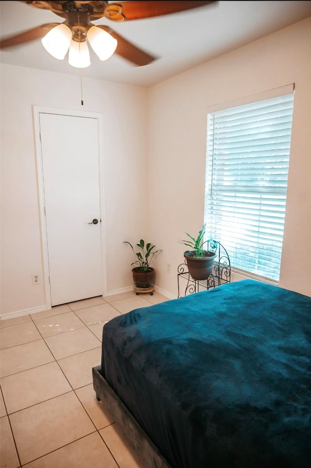 tiled bedroom featuring ceiling fan