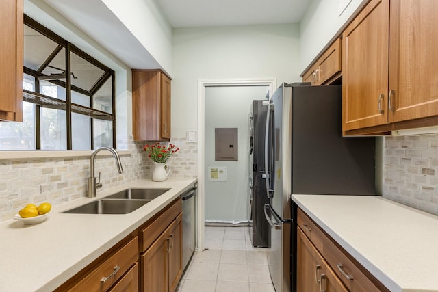 kitchen featuring appliances with stainless steel finishes, sink, light tile patterned floors, and backsplash