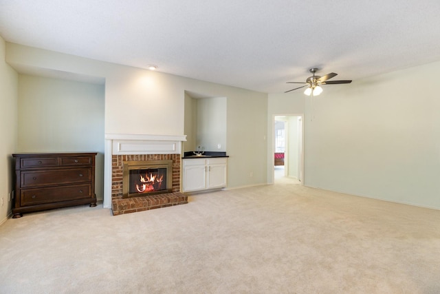 unfurnished living room with a brick fireplace, light carpet, and ceiling fan