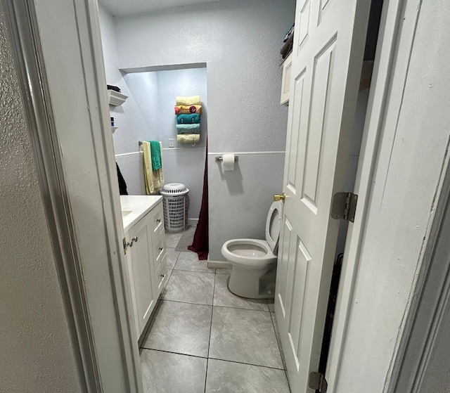 bathroom featuring vanity, toilet, and tile patterned flooring