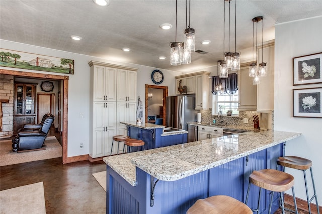 kitchen featuring appliances with stainless steel finishes, decorative light fixtures, tasteful backsplash, a kitchen breakfast bar, and a center island