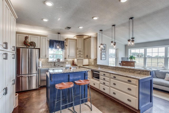 kitchen featuring appliances with stainless steel finishes, pendant lighting, a kitchen breakfast bar, a center island, and kitchen peninsula