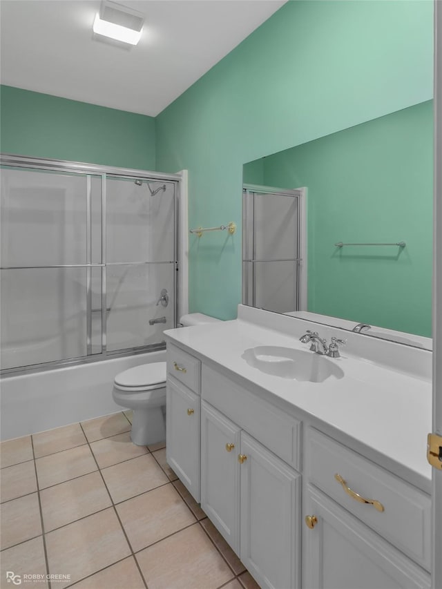 full bathroom featuring vanity, tile patterned floors, shower / bath combination with glass door, and toilet