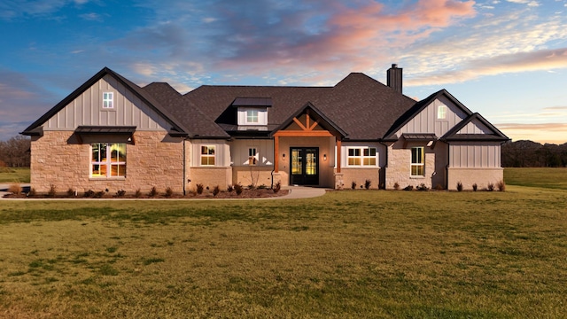 view of front of property featuring board and batten siding, a chimney, french doors, and stone siding