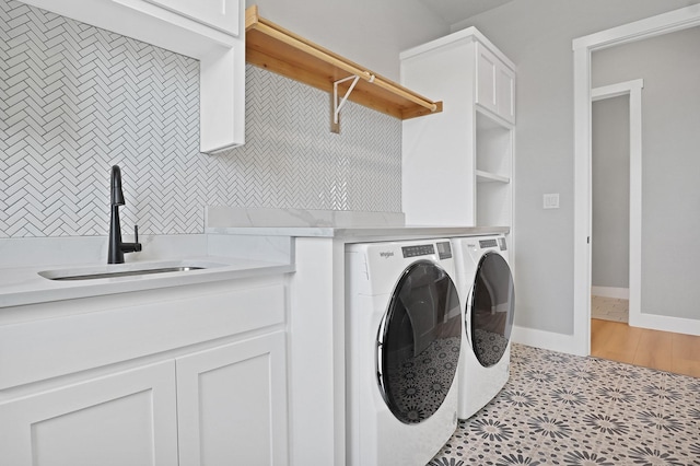 laundry area with cabinets, independent washer and dryer, and sink