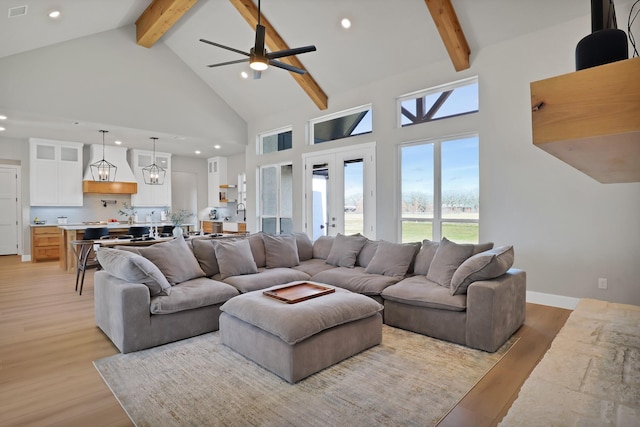 living room featuring beam ceiling, light hardwood / wood-style flooring, high vaulted ceiling, and french doors