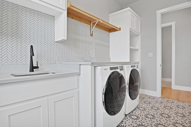 washroom with a sink, cabinet space, and washing machine and dryer