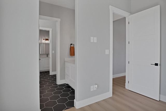 hall featuring baseboards and dark wood-style flooring