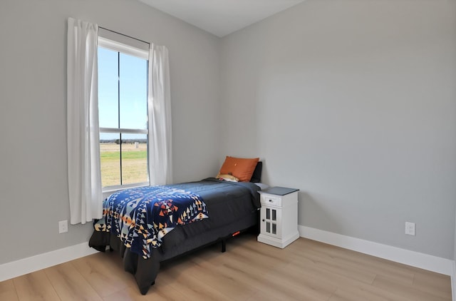 bedroom featuring wood finished floors and baseboards
