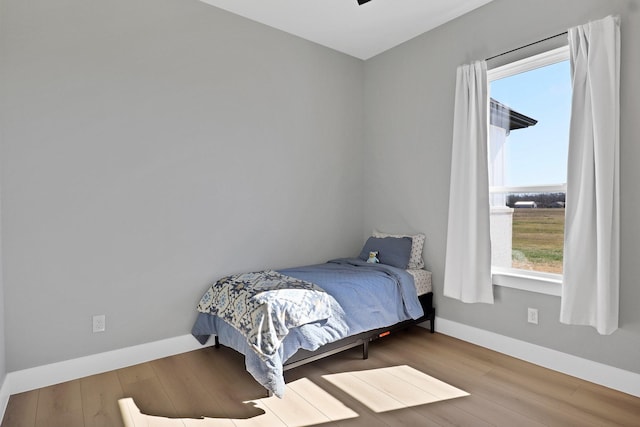 bedroom featuring wood finished floors and baseboards