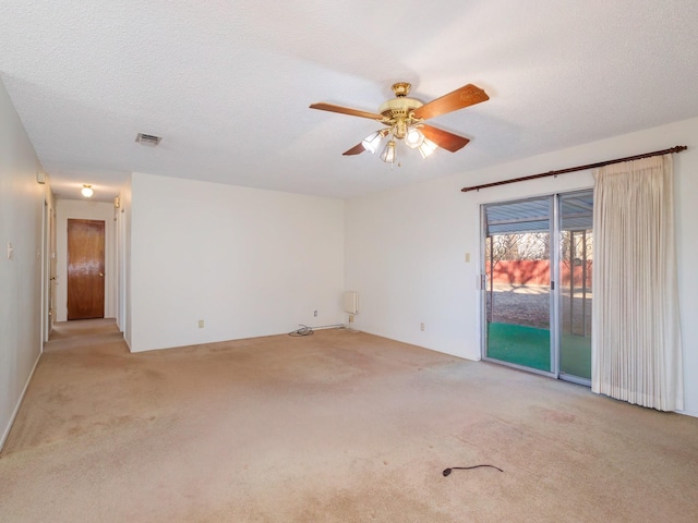 carpeted empty room featuring ceiling fan and a textured ceiling