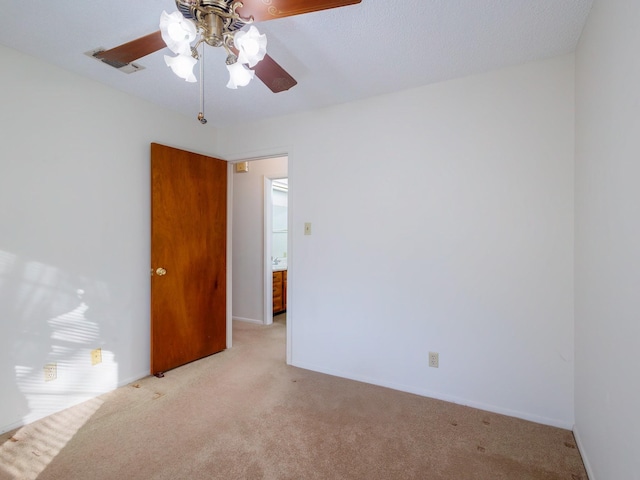 carpeted spare room featuring ceiling fan