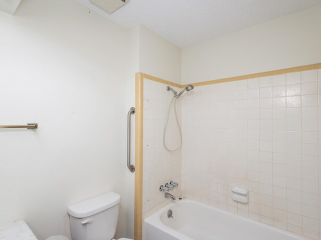 bathroom featuring tiled shower / bath, a textured ceiling, and toilet