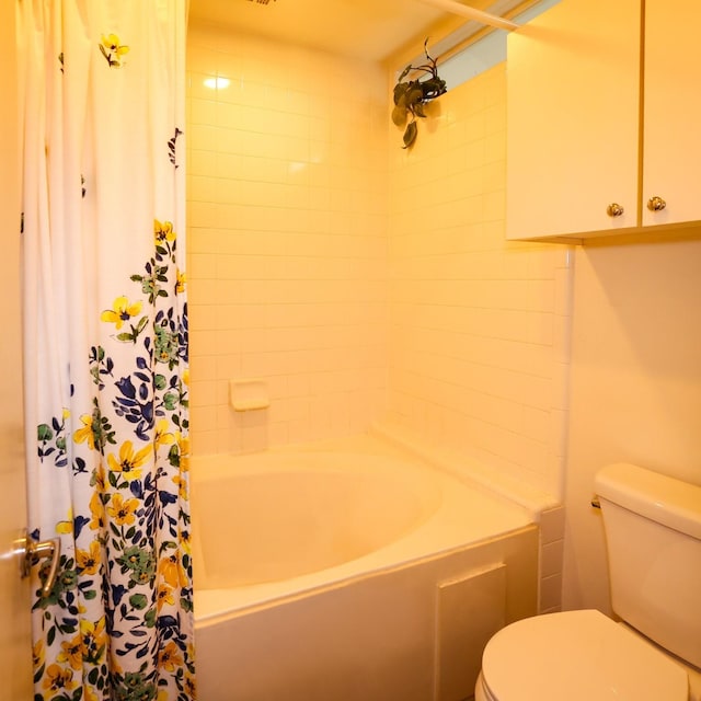 bathroom featuring toilet and shower / bath combo with shower curtain