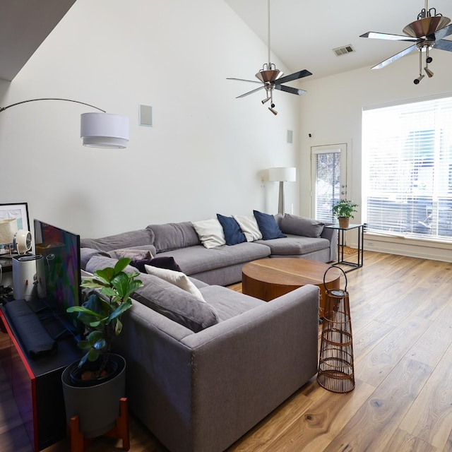 living room with a wealth of natural light, wood-type flooring, and ceiling fan