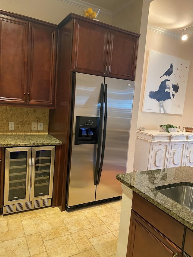 kitchen featuring stainless steel fridge, wine cooler, ornamental molding, decorative backsplash, and dark stone counters